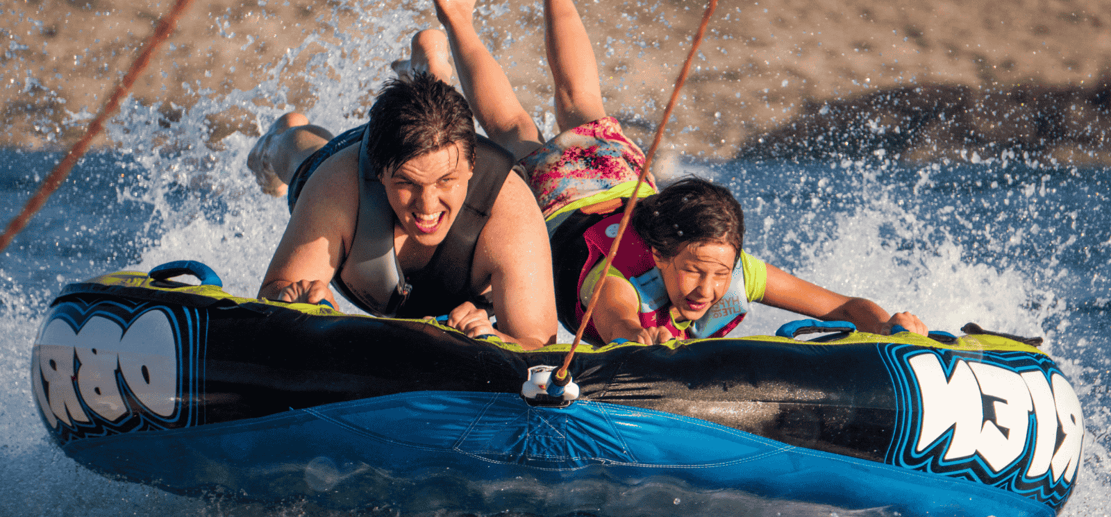 Girl & Boy on lake tube going fast